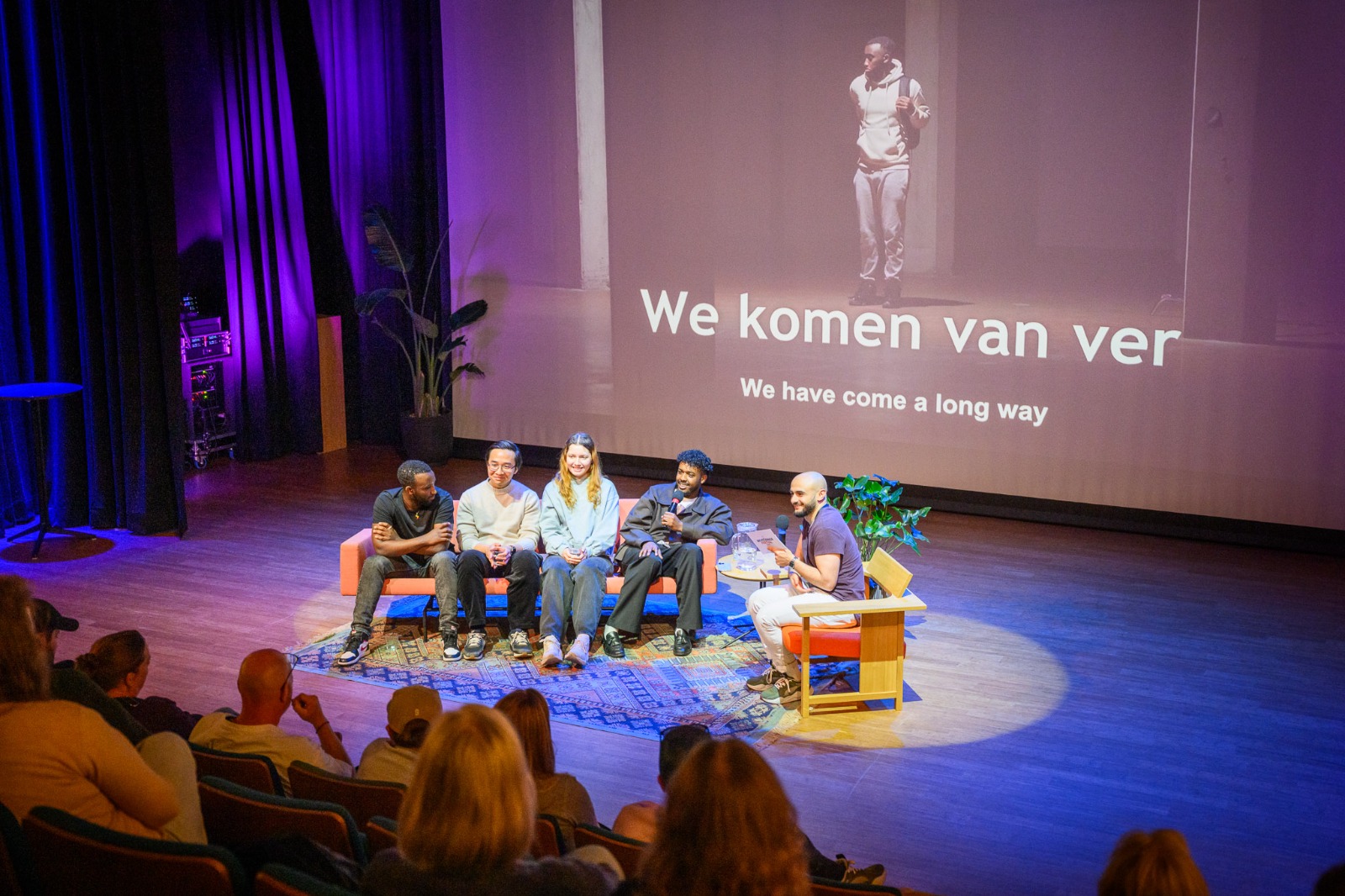 Nagesprek na de premiere van Wij Komen Van Ver, met de filmtitel geprojecteerd
